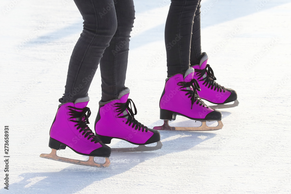 feet in pink skates on an ice rink. sports, Hobbies and recreation of active people. feet in pink skates on an ice rink. sports, Hobbies and recreation of active people.