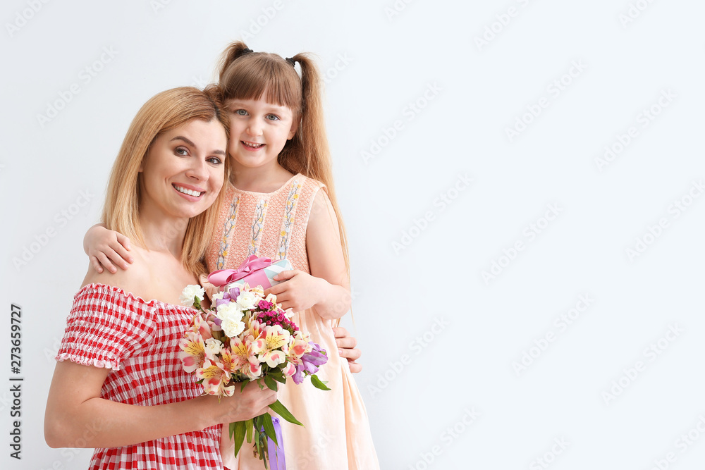 Little girl greeting her mother on light background Little girl greeting her mother on light background