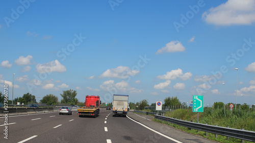 Cars and trucks on motorway with four lanes