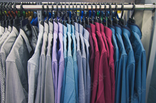 Wallpaper Mural Colorful selection of clothes for men hanging on hangers in shopping mall for store sale concept Torontodigital.ca