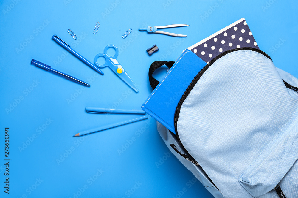 School backpack with stationery on color background - obrazy, fototapety, plakaty 