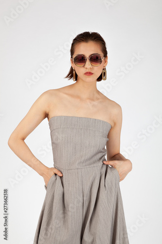 Asian Chinese Fashion influencer modeling in grey jumpsuit isolated in white background