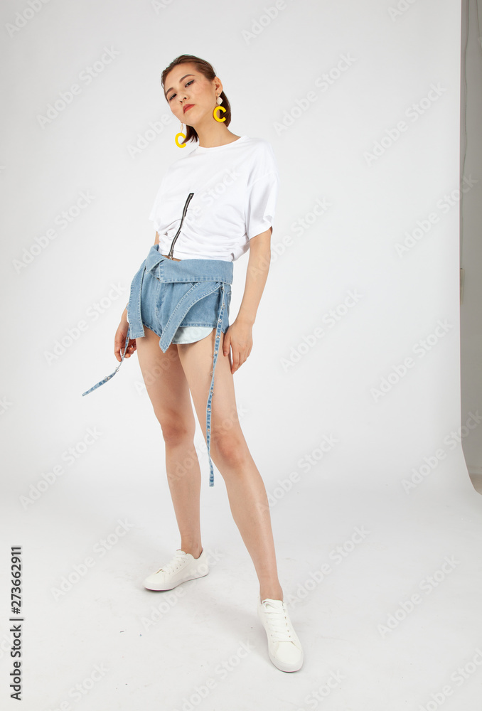 Asian Chinese Fashion influencer modeling in tight jeans short isolated in white background Asian Chinese Fashion influencer modeling in tight jeans short isolated in white background