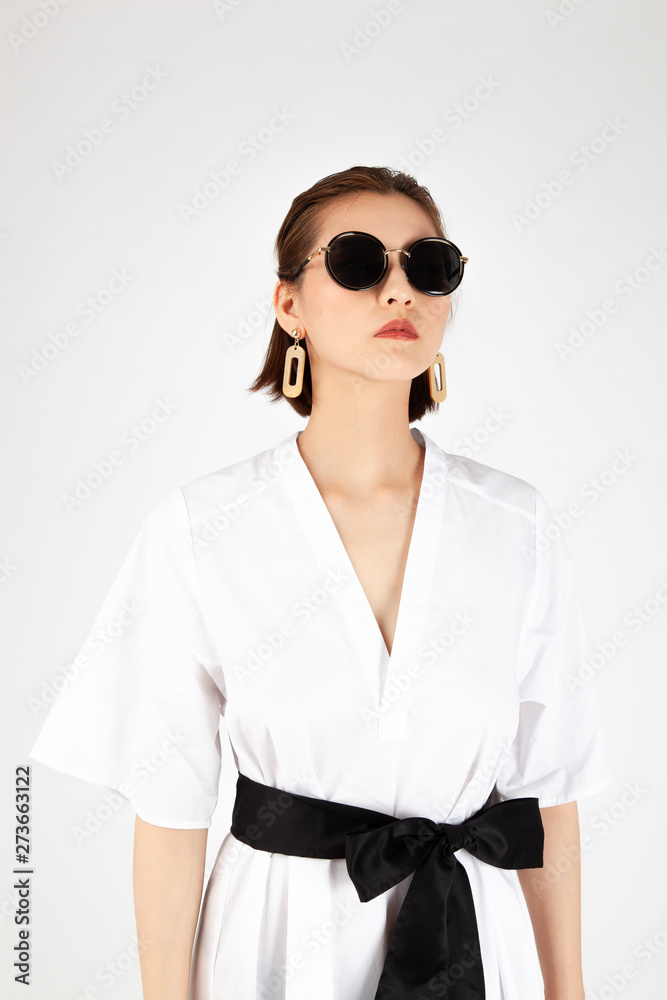 Asian Chinese Fashion influencer modeling in white dress with a tote bag isolated in white background Asian Chinese Fashion influencer modeling in white dress with a tote bag isolated in white background