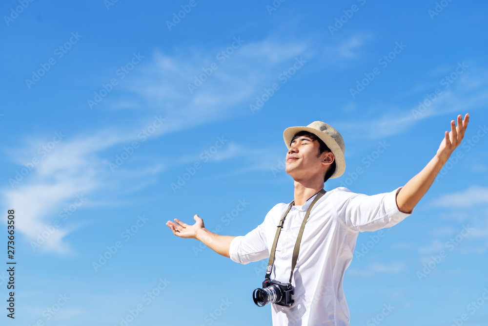 Candid of young attractive asian man close eyes, deep breath and wide open  arms in blue