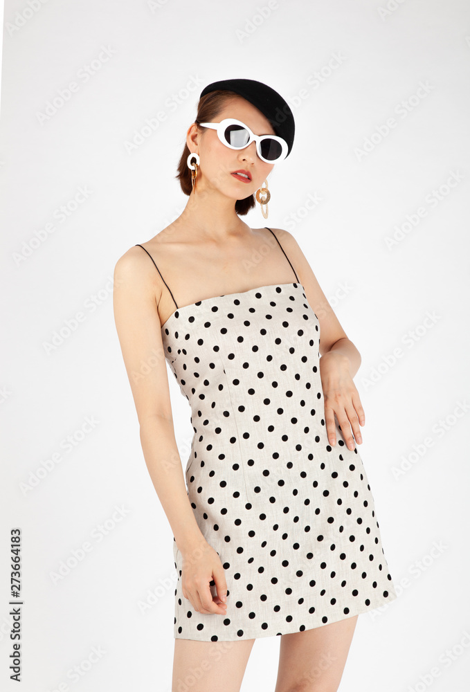 Asian Chinese Fashion influencer modeling in a white dotted mini skirt isolated in white background Asian Chinese Fashion influencer modeling in a white dotted mini skirt isolated in white background