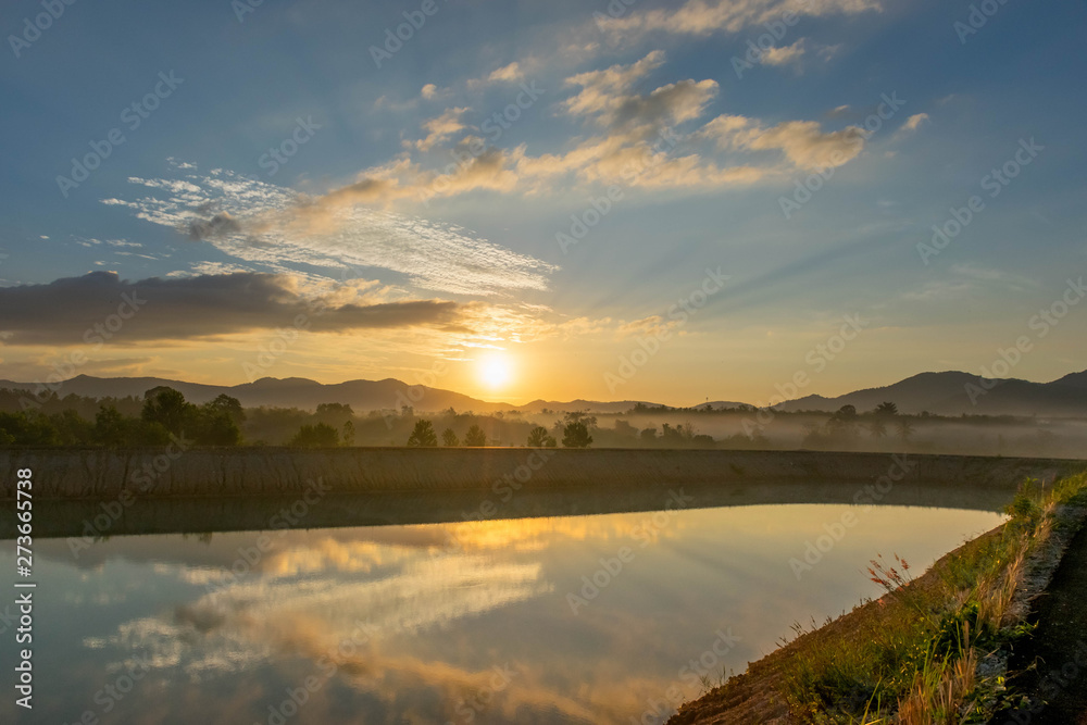 Obraz premium Sunrise view At Ban Na Thong Suk Reservoir, Songkhla Province, Thailand