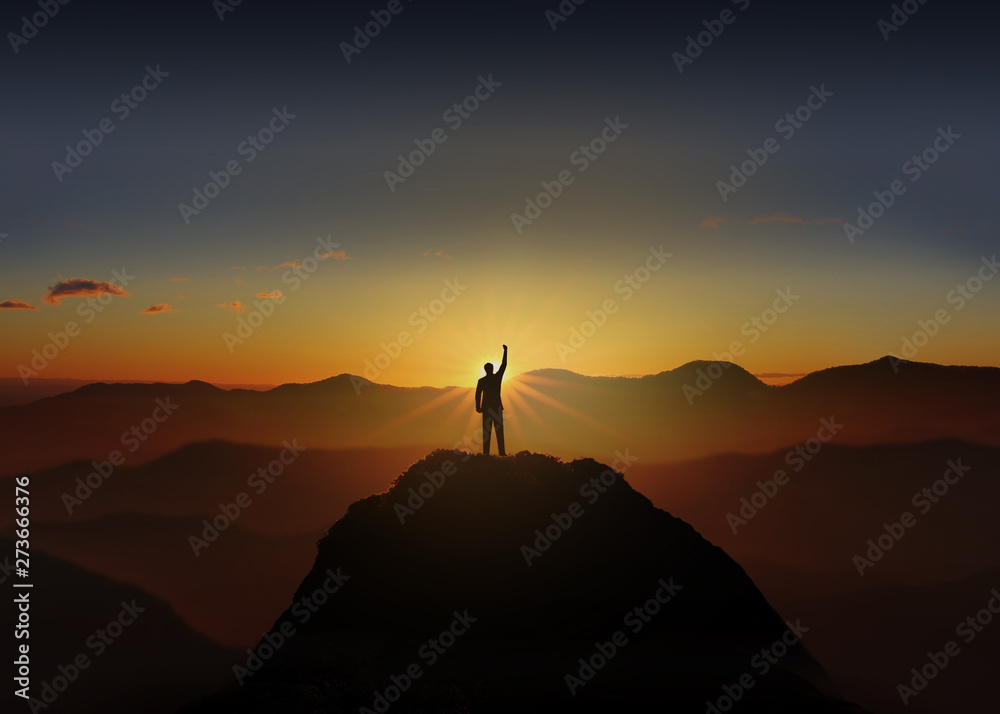 Silhouette of Business man Celebration Success Happiness on a mountain top Sunset. Success Concept.