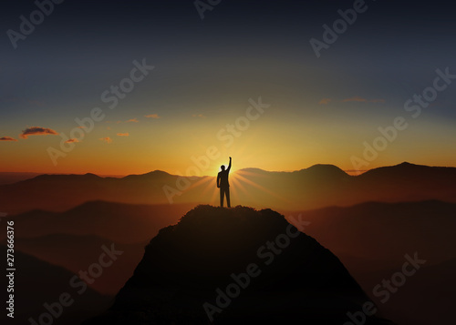Obraz na plátně Silhouette of Business man Celebration Success Happiness on a mountain top Sunset