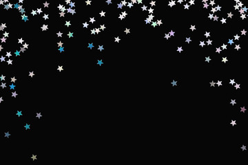 Iridescent Silver stars confetti isolated on black. Festive holiday background. Glowing sparkles frame, flat lay.