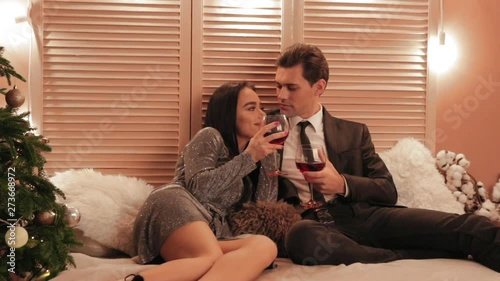 Beautiful woman in nice grey dress laughing at her man's jokes while drinkindg red wine in a hotel slow motion photo