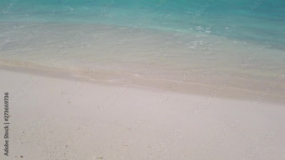 small waves dashing in a white sand beach in the Philippines. The sand has a soft pink tone small waves dashing in a white sand beach in the Philippines. The sand has a soft pink tone