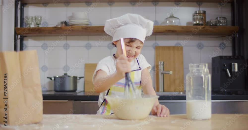 Caucasian boy prepares dough, fools and smiles Caucasian boy prepares dough, fools and smiles