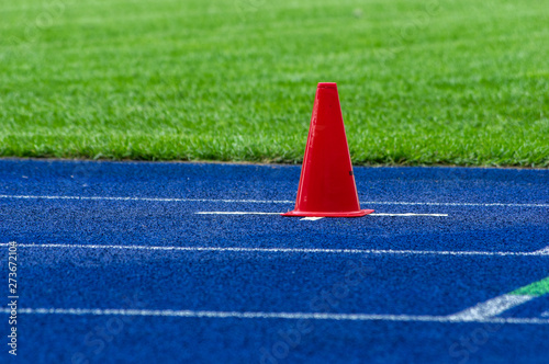 traffic cone on blue tartan track in stadium 