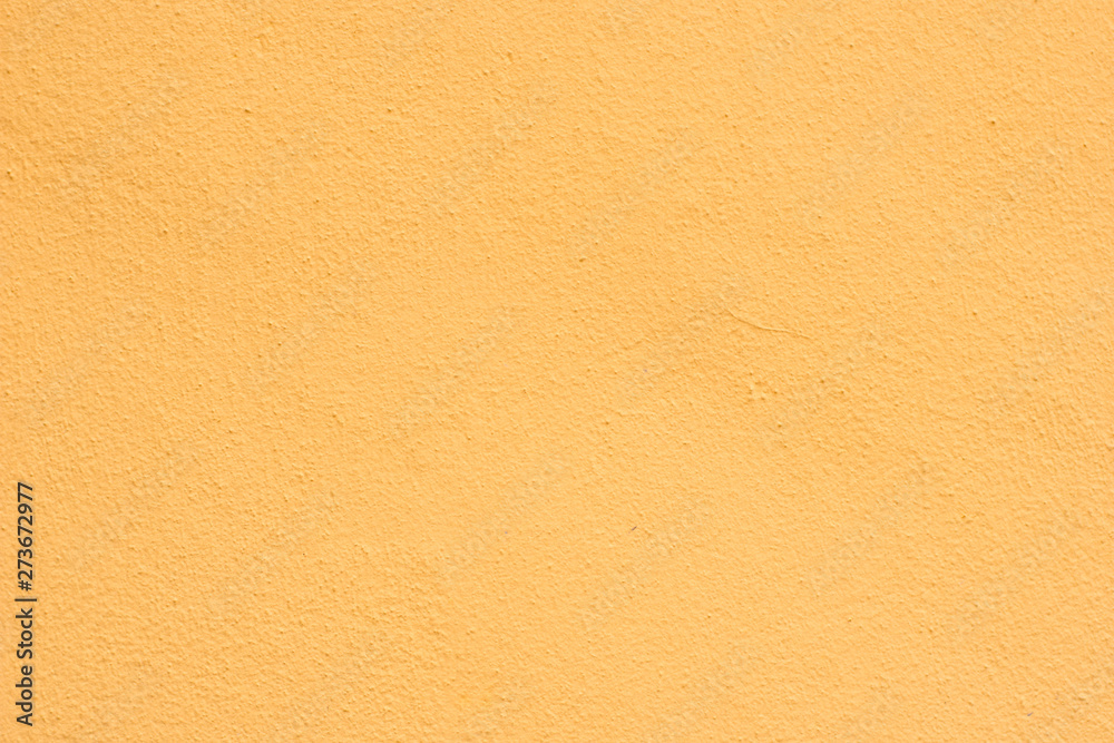 Background of a yellow stucco coated and painted exterior, rough cast of cement and concrete wall texture Background of a yellow stucco coated and painted exterior, rough cast of cement and concrete wall texture