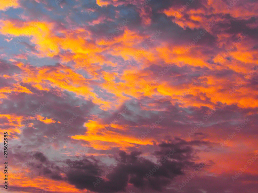 Dramatic sunset sky background with fiery clouds, yellow, orange and pink colors Dramatic sunset sky background with fiery clouds, yellow, orange and pink colors