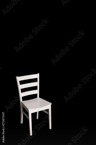 Modern white chair on black background.