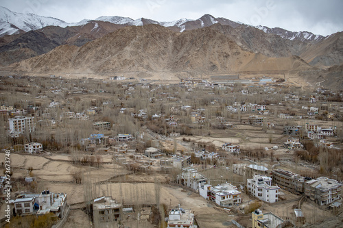 Leh Ladakh city view from Shanti Stupa. Beautiful amazing village in the valley with snow mountain at background. Ladakh, India.