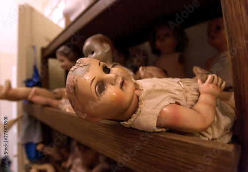 Tela Eyeless face of doll in shelf with vintage toys of the Doll Hospital, antique do