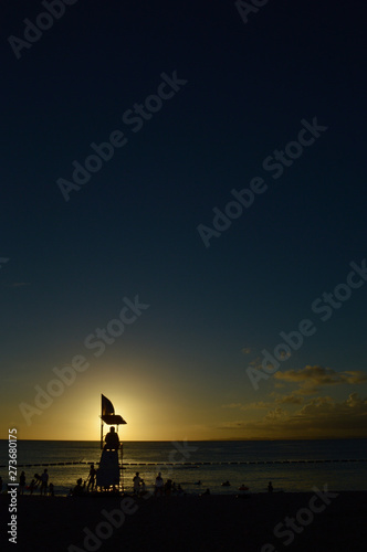 輝く夕日とシルエットの海水浴の監視台 © Ta-c