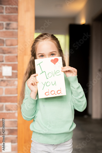 Pretty daughter with holiday card for father