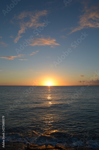 水平線に沈むオレンジ色の夕日 © Ta-c