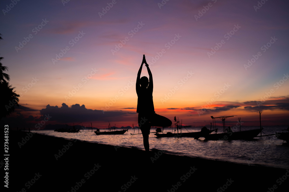 Silhouette yoga on the beach at sunset.