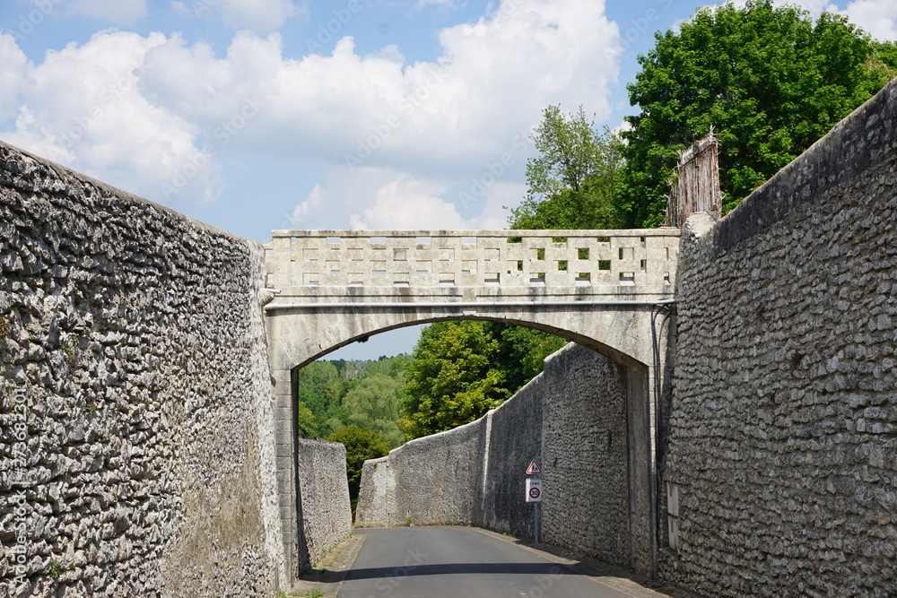 old stone bridge over the road with high stone walls
