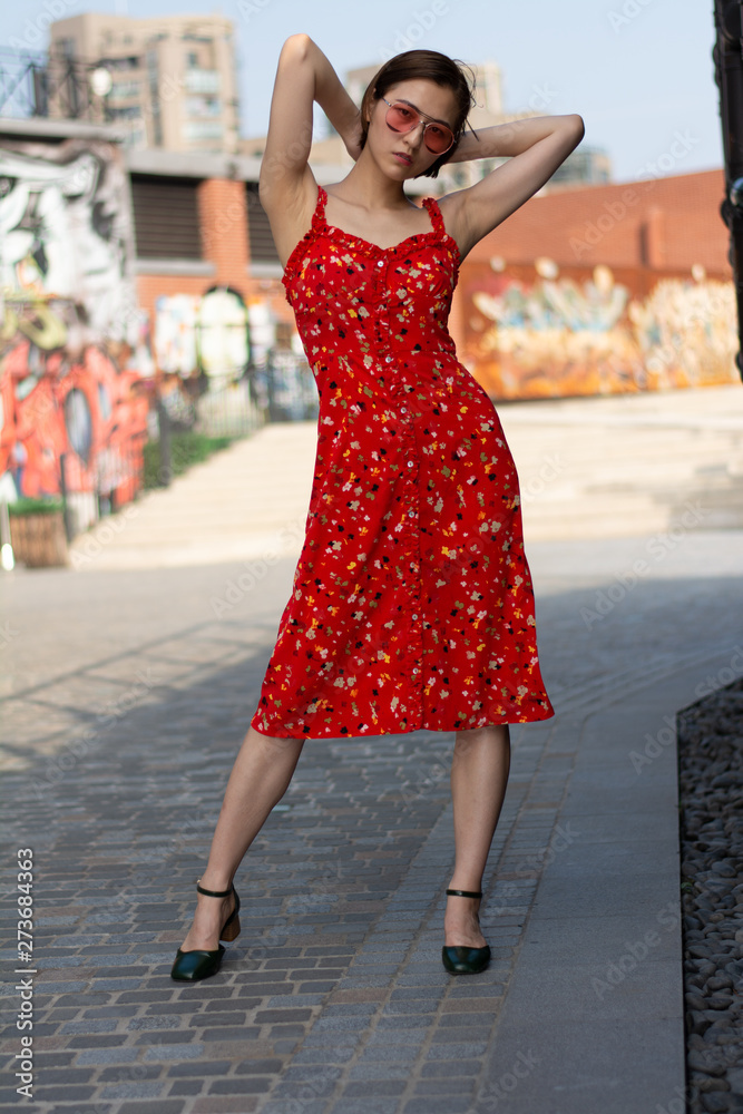 Asian Chinese model girl influencer street shot. Wearing red floral printed dress. Street view background. Asian Chinese model girl influencer street shot. Wearing red floral printed dress. Street view background.