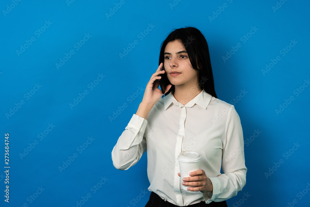 succesfull business woman with smartphone, and coffee seriously speak trhoug phone.