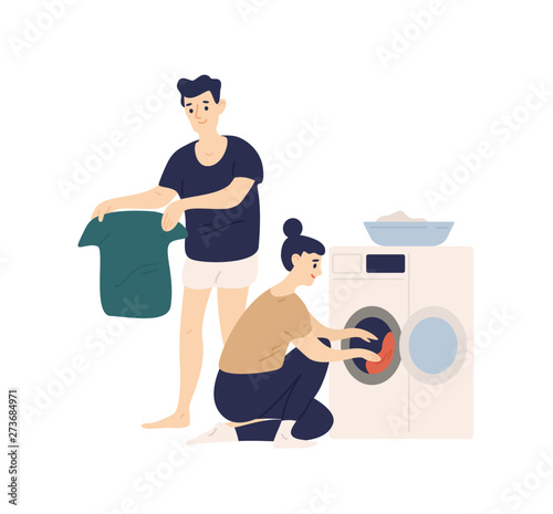 Adorable funny couple sorting clothes and putting it in washing machine