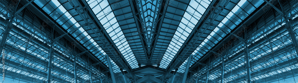 Obraz premium Wide screen of large cargo warehouse roof. Made from steels and glasses. Adjust color theme to blue tone. 