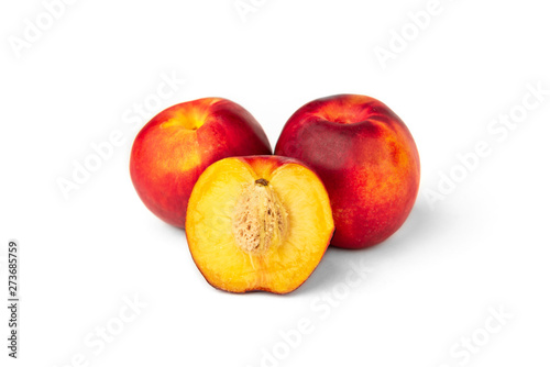 Two peaches and a half isolated on white background.