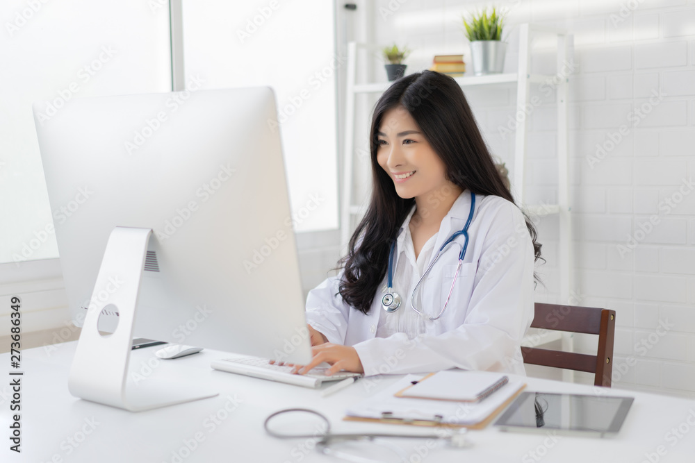 Asian female doctor work at hospital office desk giving patient convenience online service advice, smiling write a prescription order medical with smartphone, health care, preventing disease concept. Asian female doctor work at hospital office desk giving patient convenience online service advice, smiling write a prescription order medical with smartphone, health care, preventing disease concept.