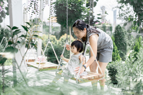 Photography Thai young Asian mother and daughter play swing and both are very happy because spent together