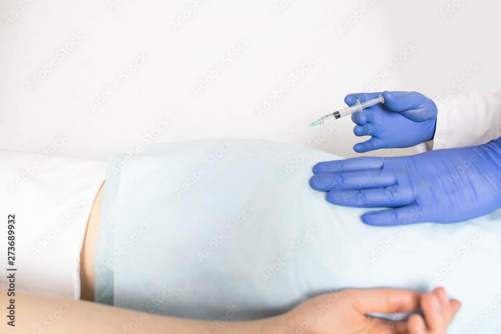 Doctor proctologist treats a patient for hemorrhoids with the help of modern method sclerotherapy, white background, treatment haemorrhoids, copy space Doctor proctologist treats a patient for hemorrhoids with the help of modern method sclerotherapy, white background, treatment haemorrhoids, copy space