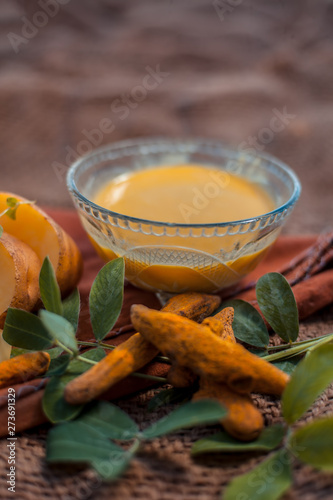 Potato face mask consisting of grated potato and some turmeric powder or haldi in a glass bowl on jute bags surface to brighten the skin, kills bacteria and germs.