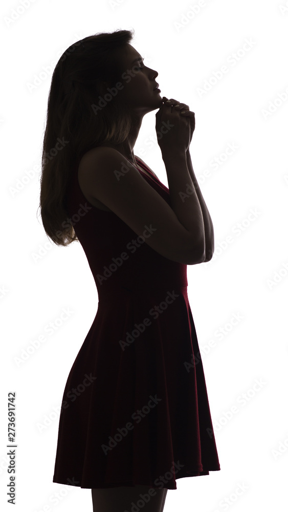 profile silhouette of a young woman in dress praying, figure of desperate beautiful girl on a white isolated background, concept religion