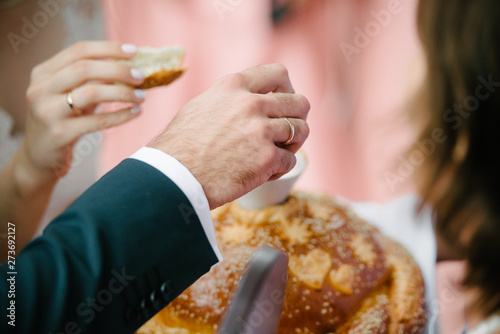 The groom breaks off a piece of the wedding loaf