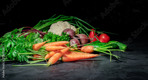 Different raw vegetables with leaf lettuce on dark background. Healthy eating and healthy organic food concept