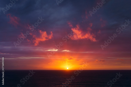 beautiful red dusk over the sea with sun rays