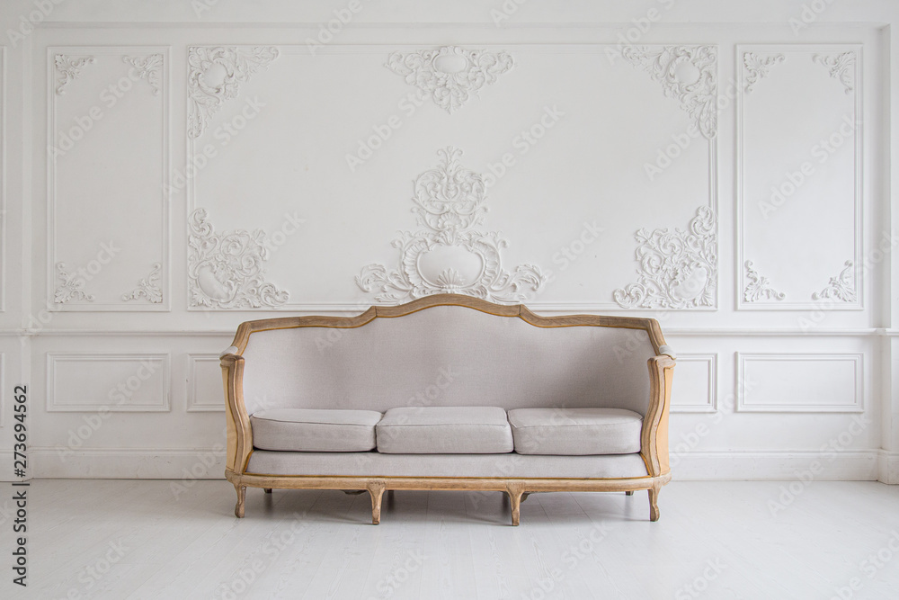 Luxurious bright Rococo interior with a large sofa and stucco on the walls. Selective focus. - obrazy, fototapety, plakaty 