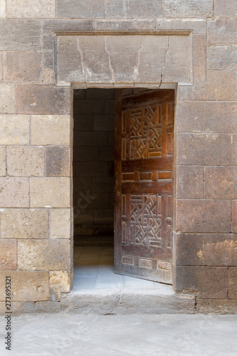 Wooden grunge old door and stone bricks wall, leading to Zeinab Khatoun old historic house, Old Cairo, Egypt photo