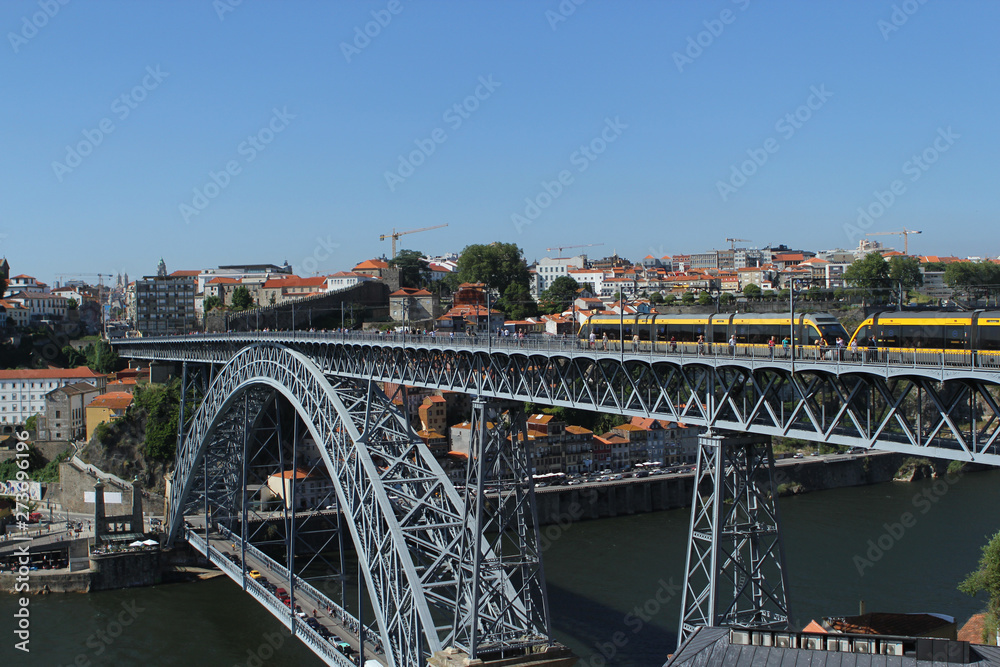 Obraz premium PORTO, PORTUGAL, JUNE 2018: view of the old city of Porto lies on the hills of the right bank of the Douro River and the famous bridge of Ponti di Don Luis I