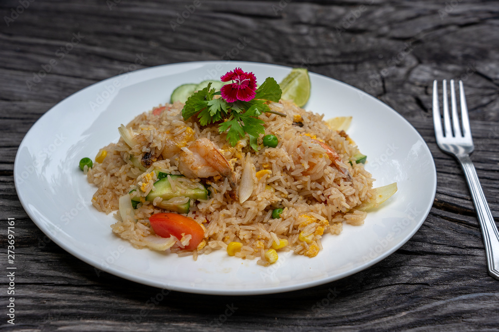 Fried rice with shrimps and vegetables in a white dish on an old wooden table, close up . Thai food , Thai cuisine Fried rice with shrimps and vegetables in a white dish on an old wooden table, close up . Thai food , Thai cuisine