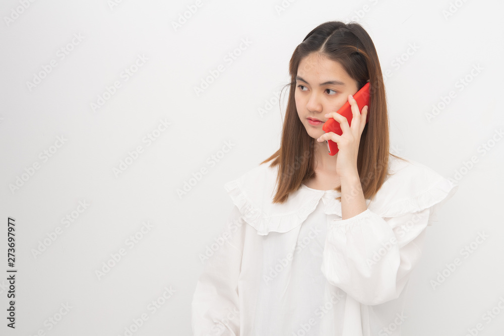 Portrait of a serious woman wearing white shirt, uses a smartphone on white background free from copy space. Female unexpected, worried expression. Portrait of a serious woman wearing white shirt, uses a smartphone on white background free from copy space. Female unexpected, worried expression.