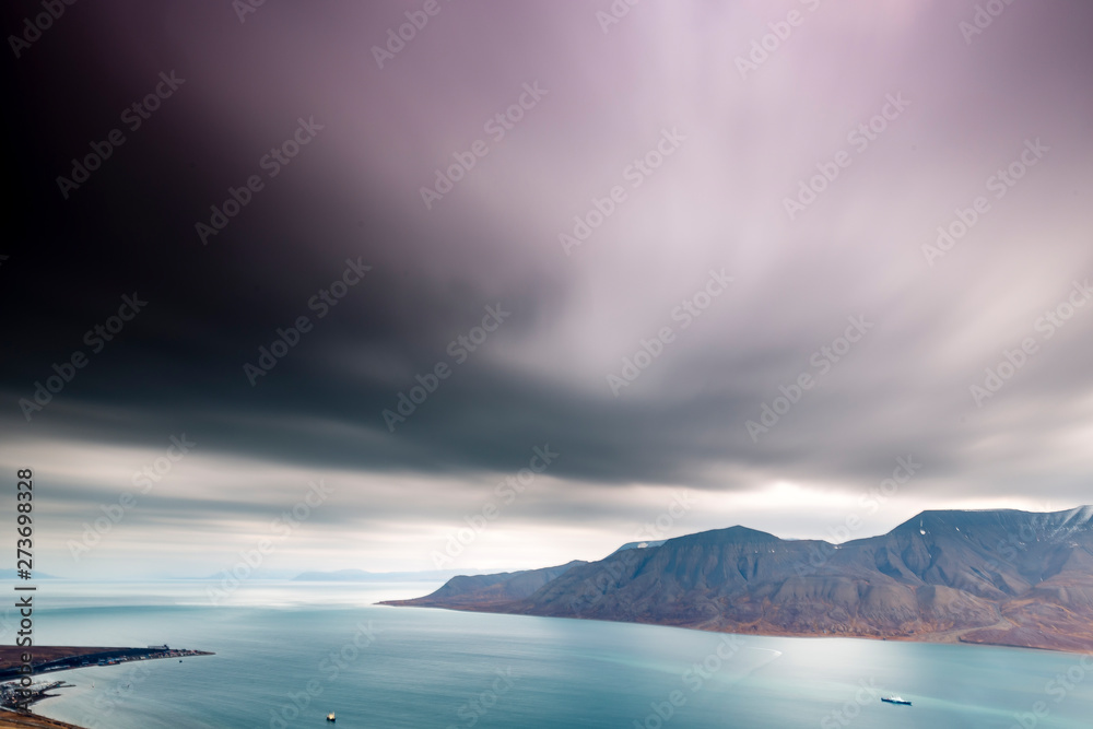 Svalbard mountain landscape, view from above Longyearbyen at Adventdalen Fjord in late autumn with flodding dark clouds, moody look
