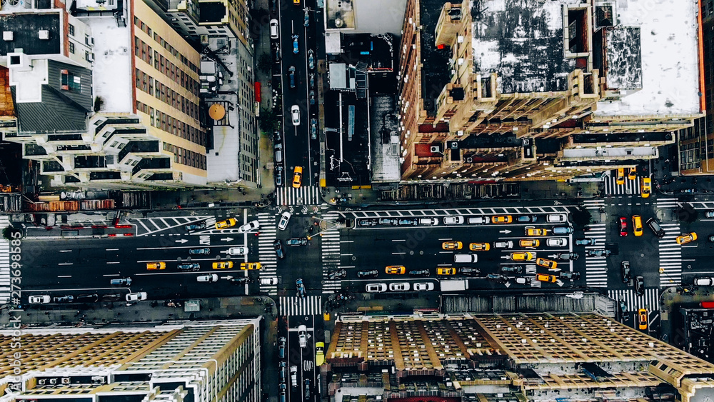 Aerial view of New York downtown building roofs. Bird's eye view from helicopter of cityscape metropolis infrastructure, traffic cars, yellow cabs moving on city streets and crossing district avenues Aerial view of New York downtown building roofs. Bird's eye view from helicopter of cityscape metropolis infrastructure, traffic cars, yellow cabs moving on city streets and crossing district avenues