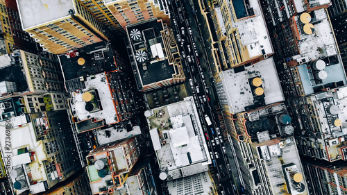 Aerial view of New York downtown building roofs with water towers. Bird's eye view from helicopter of cityscape metropolis infrastructure, traffic cars moving on city streets and district avenues
