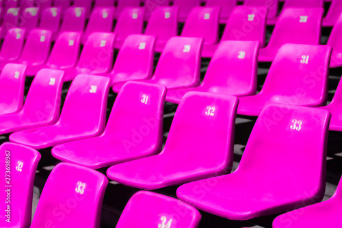 Empty Pink plastic chair row In a large meeting.shallow focus effect.